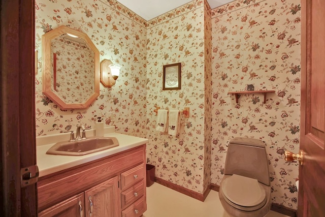 half bath with wallpapered walls, vanity, and toilet