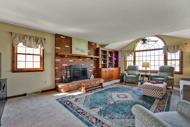 carpeted living room featuring lofted ceiling, baseboards, visible vents, and a fireplace