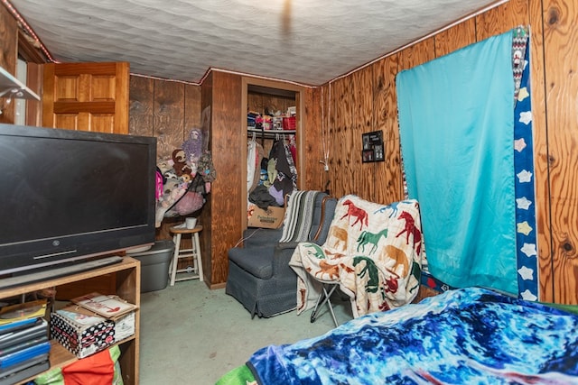 bedroom with wood walls, a textured ceiling, and a closet