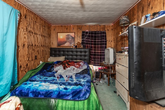 carpeted bedroom featuring wooden walls and a textured ceiling