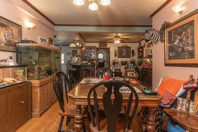 dining room with ceiling fan, crown molding, and light hardwood / wood-style floors