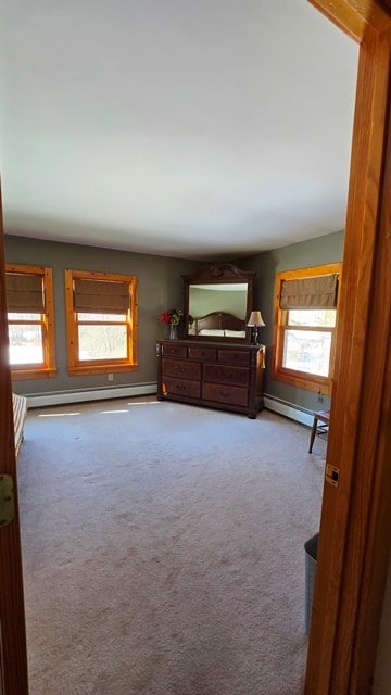 bedroom with a baseboard radiator and light colored carpet