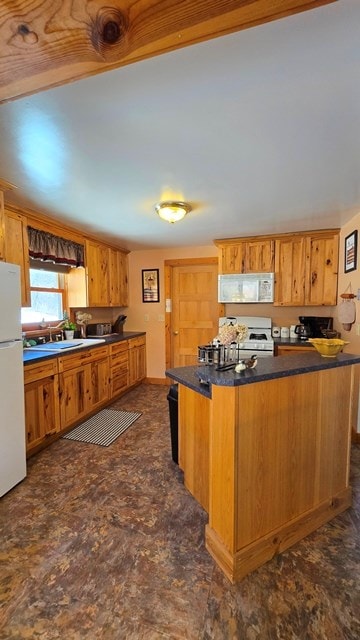 kitchen with sink, white appliances, and kitchen peninsula