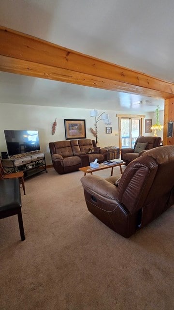 carpeted living room with beam ceiling