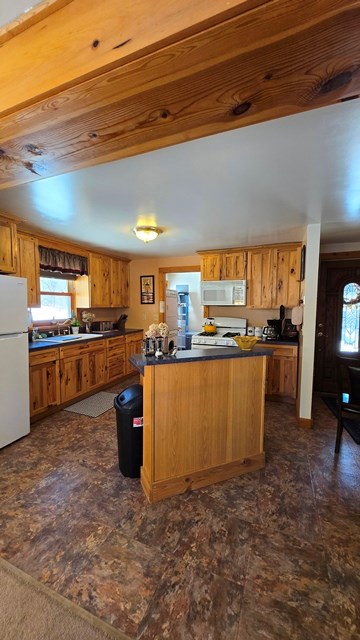 kitchen featuring sink, wooden ceiling, white appliances, and kitchen peninsula