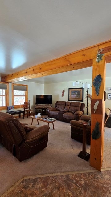 carpeted living room with beamed ceiling