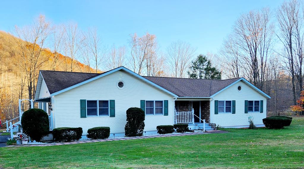 ranch-style home with covered porch and a front yard