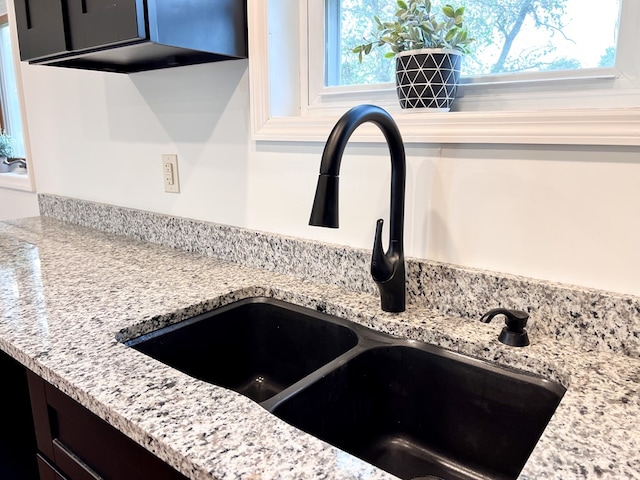 details with a sink and light stone countertops