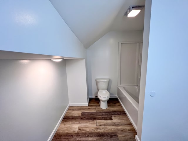 bathroom with wood finished floors, visible vents, baseboards, vaulted ceiling, and toilet