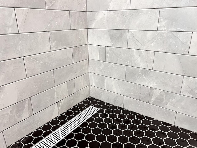 interior details with a tile shower