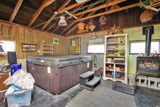 miscellaneous room with lofted ceiling and a wood stove