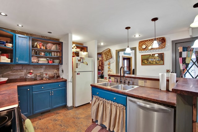 kitchen featuring tasteful backsplash, freestanding refrigerator, blue cabinets, stainless steel dishwasher, and a sink