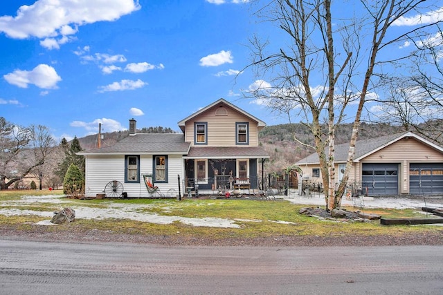 traditional home with covered porch, an outdoor structure, a detached garage, and a front lawn