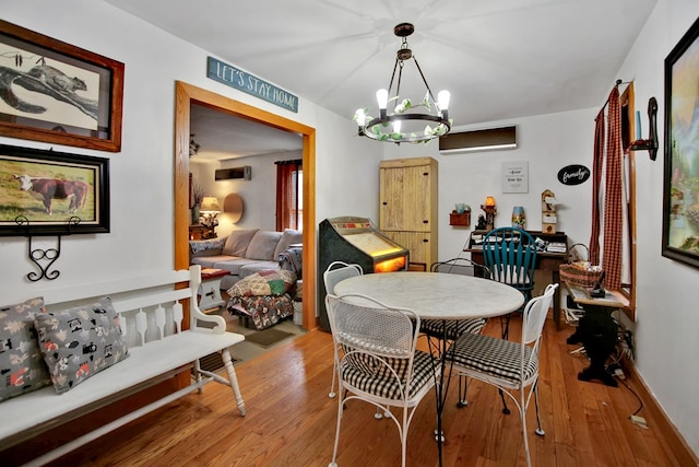 dining area featuring baseboards, an inviting chandelier, and wood finished floors