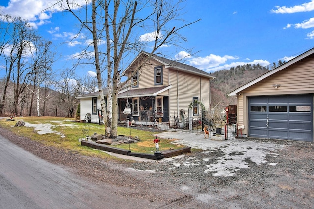 view of front facade with a garage, a porch, and a front lawn