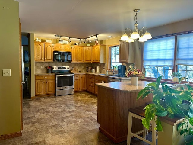 kitchen with sink, hanging light fixtures, backsplash, a chandelier, and appliances with stainless steel finishes