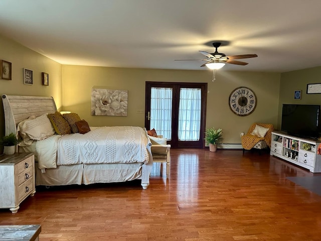 bedroom featuring ceiling fan, wood-type flooring, and a baseboard heating unit