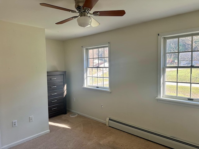 unfurnished room featuring baseboard heating, ceiling fan, and light colored carpet