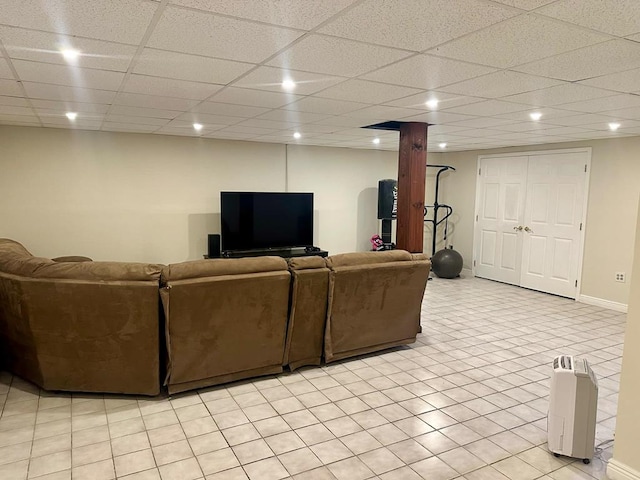 living room featuring a drop ceiling and light tile patterned flooring