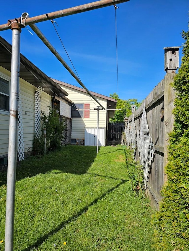 view of side of property featuring fence and a yard