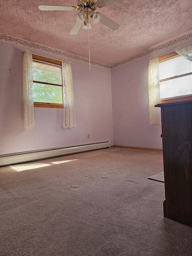 carpeted spare room with baseboards, a textured ceiling, a baseboard heating unit, and ceiling fan