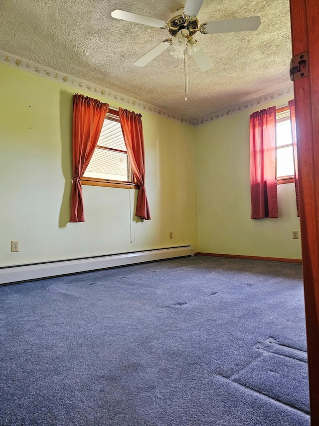 carpeted empty room featuring a ceiling fan, a textured ceiling, and a baseboard heating unit