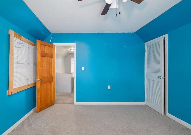 unfurnished bedroom featuring ceiling fan, light colored carpet, and lofted ceiling