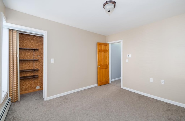 unfurnished bedroom with baseboard heating and light carpet