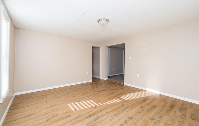 empty room featuring a drop ceiling and wood-type flooring