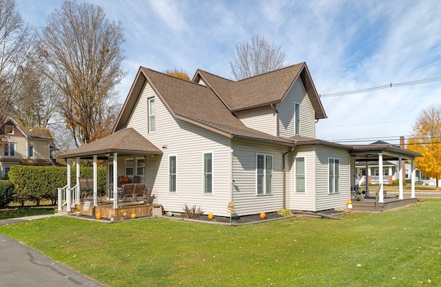 back of property with a yard and covered porch