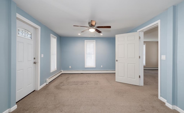 interior space featuring light carpet, ceiling fan, and a baseboard heating unit