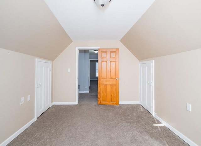 additional living space with carpet flooring and vaulted ceiling