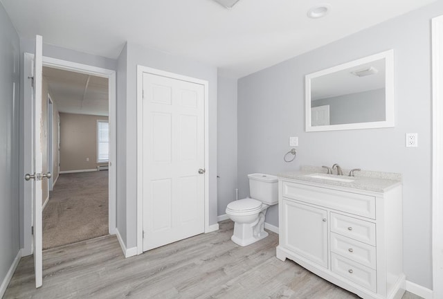 bathroom with vanity, toilet, and wood-type flooring