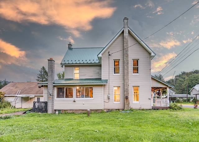 back house at dusk featuring a yard