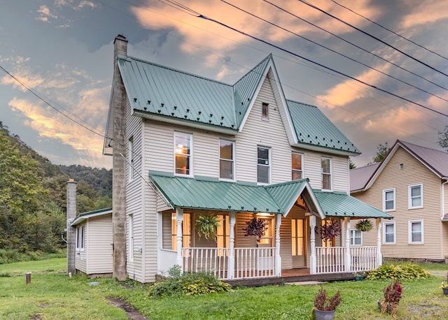 view of front facade with covered porch and a yard