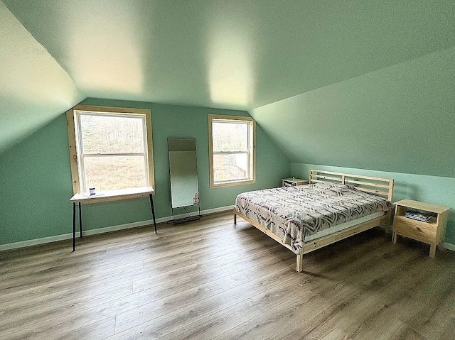 bedroom featuring vaulted ceiling and light hardwood / wood-style flooring