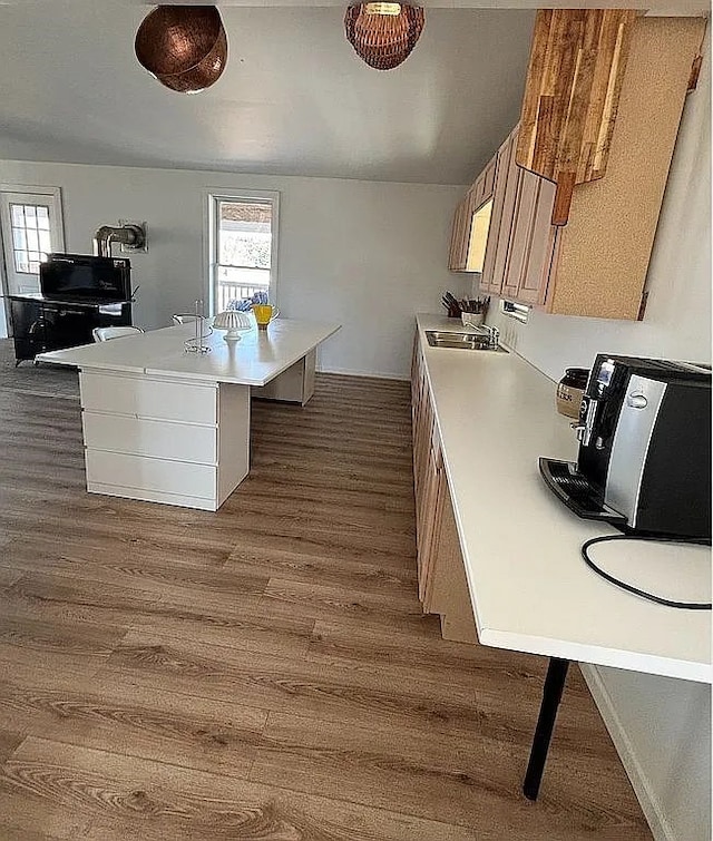 kitchen featuring a kitchen island with sink, a breakfast bar, dark wood-type flooring, and sink