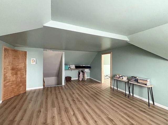 bonus room with hardwood / wood-style floors and vaulted ceiling