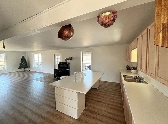 kitchen featuring a center island, dark hardwood / wood-style flooring, sink, and a breakfast bar area