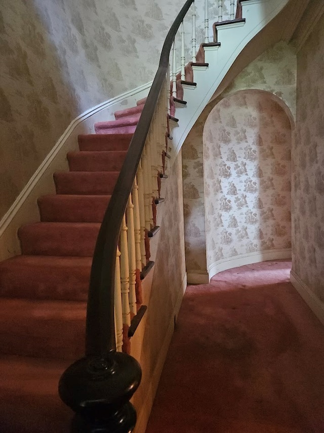 446 Pennsylvania Ave, Waverly, NY 14892 - staircase with wallpapered walls, arched walkways, and carpet flooring