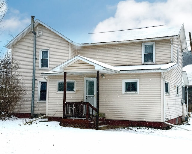 view of snow covered back of property