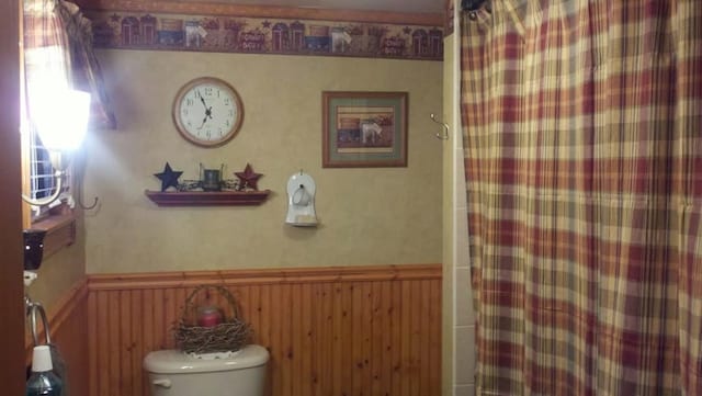 607 N W St, Coudersport, PA 16915 - bathroom with a wainscoted wall, a shower with shower curtain, and toilet