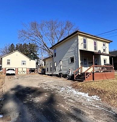 view of side of property with a porch and a garage