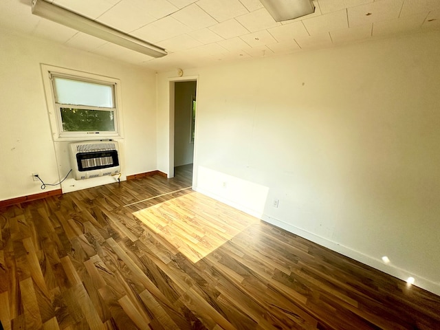 unfurnished living room featuring dark hardwood / wood-style floors and heating unit