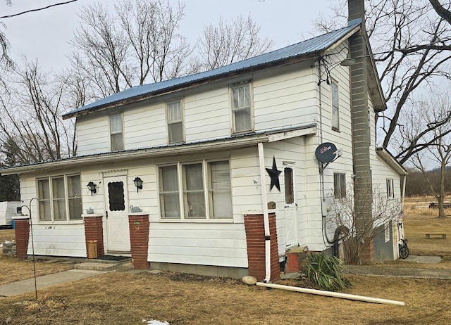 view of front of house featuring metal roof and a chimney