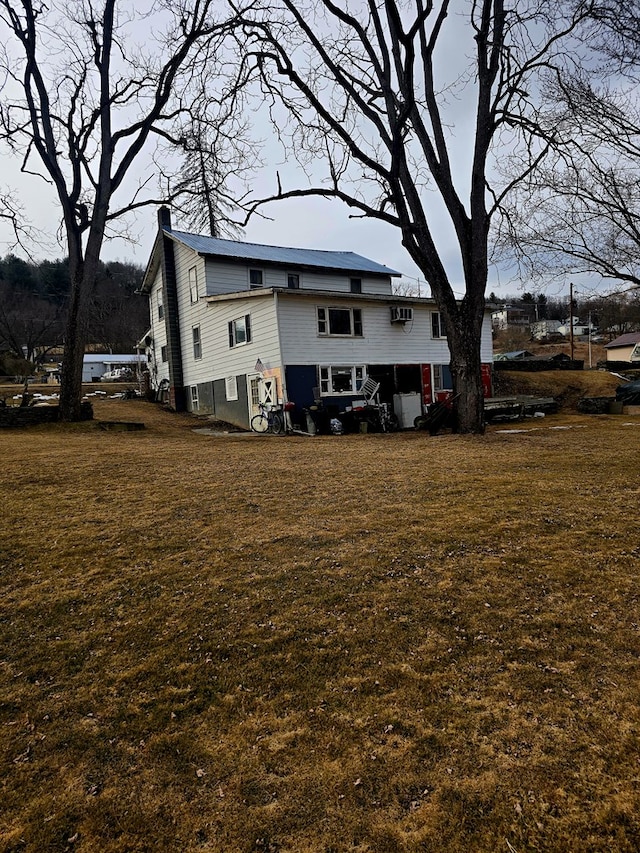 back of property with a lawn and a chimney