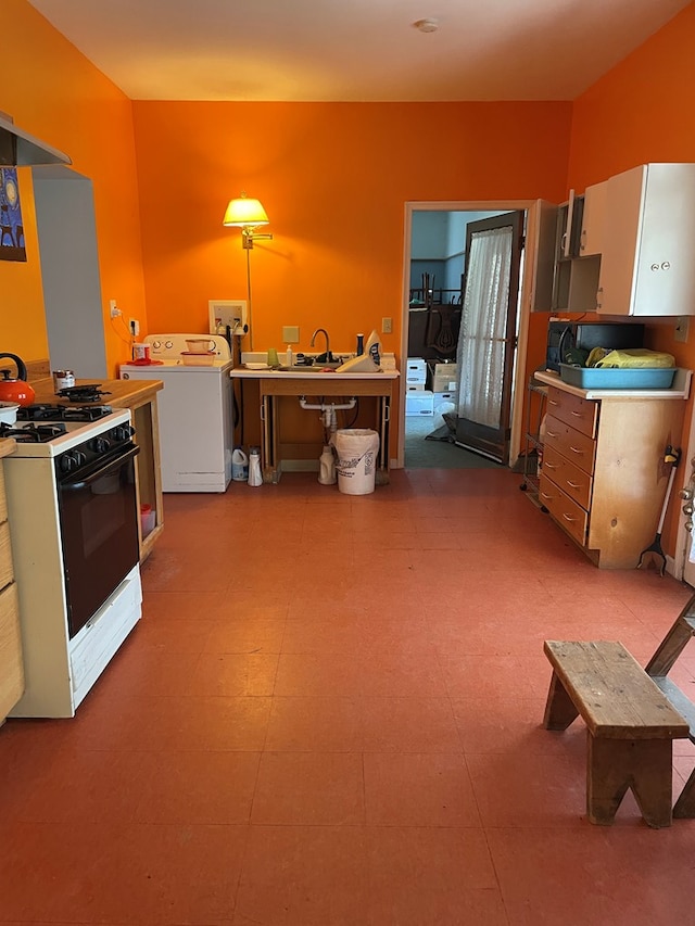 kitchen with washer / clothes dryer, white gas range, and sink