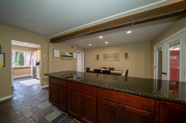 kitchen with baseboard heating and dark stone counters