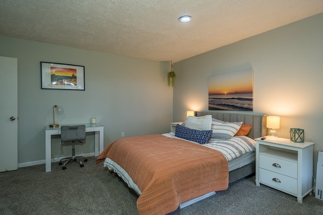 bedroom with dark colored carpet and a textured ceiling