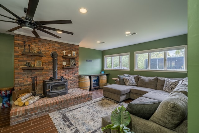 living room featuring a wood stove and ceiling fan